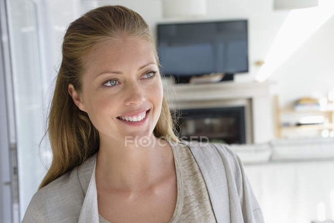 Mujer feliz mirando hacia otro lado en el salón - foto de stock