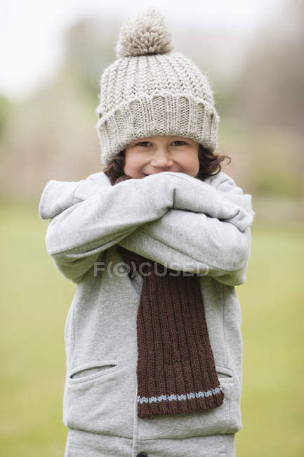 Retrato de menino sorridente usando chapéu de malha ao ar livre — Fotografia de Stock