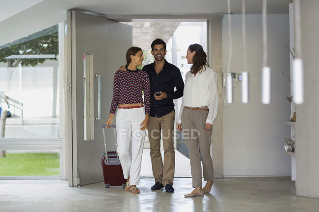 Happy woman welcoming friends at home — Stock Photo