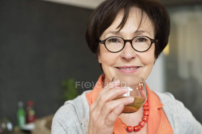 Портрет улыбающейся пожилой женщины, пьющей чай — стоковое фото