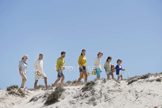 Felice passeggiata in famiglia sulla spiaggia di sabbia in estate — Foto stock