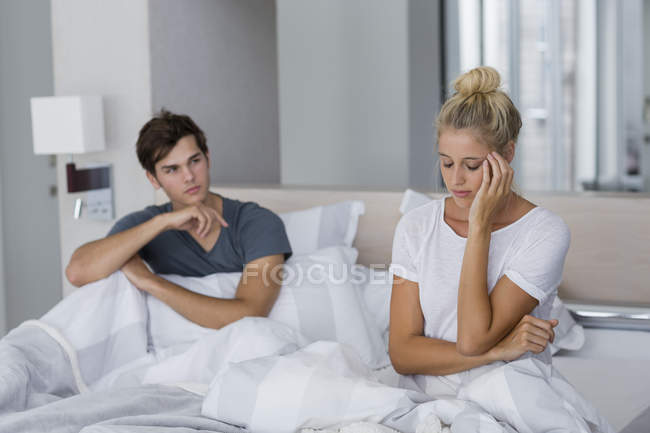 Молода пара, сидячи на ліжку з труднощі відносин — стокове фото