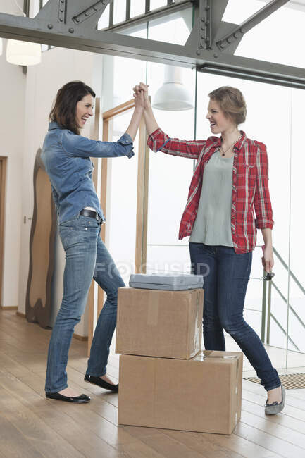 Two female friends giving high-five to each other — Stock Photo