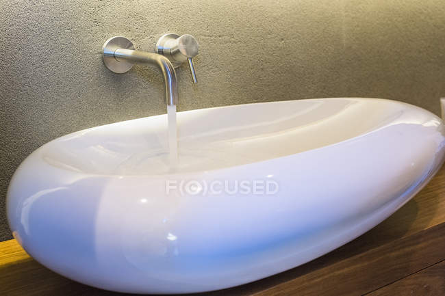 Moderno lavabo de baño con agua corriente - foto de stock