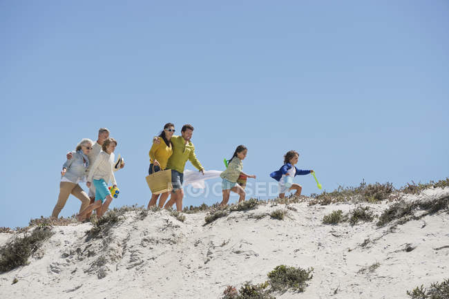 Glückliche Familie beim Wandern am Sandstrand im Sommer — Stockfoto