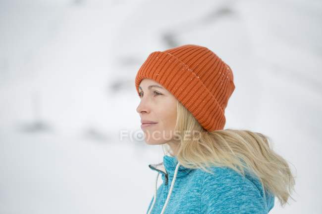 Gros plan de la femme en bonnet tricoté regardant loin en hiver à l'extérieur — Photo de stock