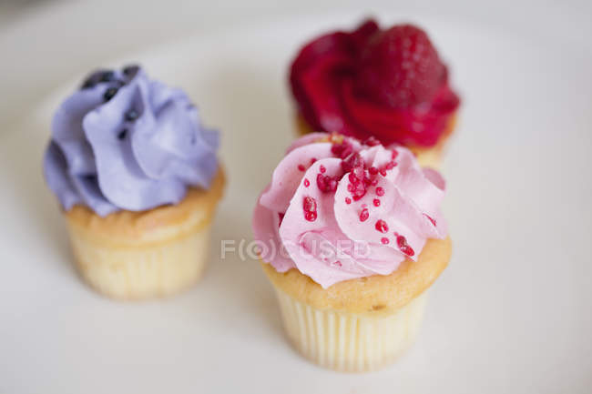 Primer plano de cupcakes con coberturas, enfoque selectivo - foto de stock