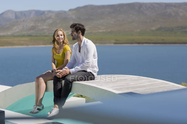 Девочка-подросток и мужчина средних лет сидят на курорте — стоковое фото