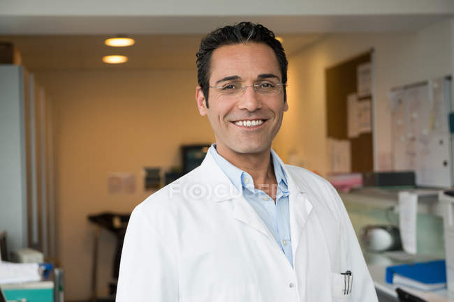 Retrato del médico masculino sonriendo en el hospital - foto de stock