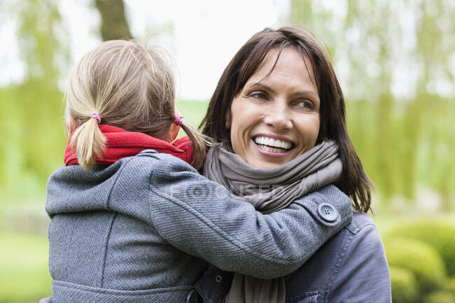 Woman carrying her daughter — Stock Photo