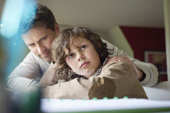 Junge denkt beim Lernen mit seinem Vater zu Hause — Stockfoto
