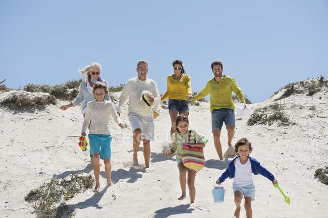 Happy family walking on sandy beach in summer — Stock Photo