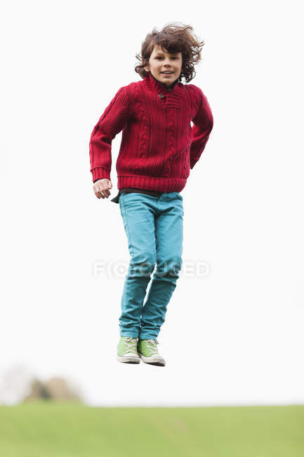 Retrato de niño juguetón saltando en el campo de otoño - foto de stock