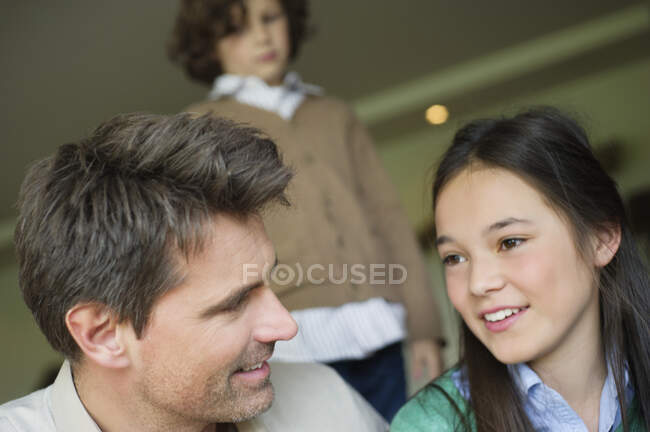 Hombre sentado con su hija en casa - foto de stock