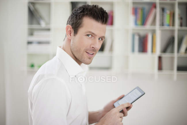 Retrato del hombre guapo usando libro electrónico - foto de stock