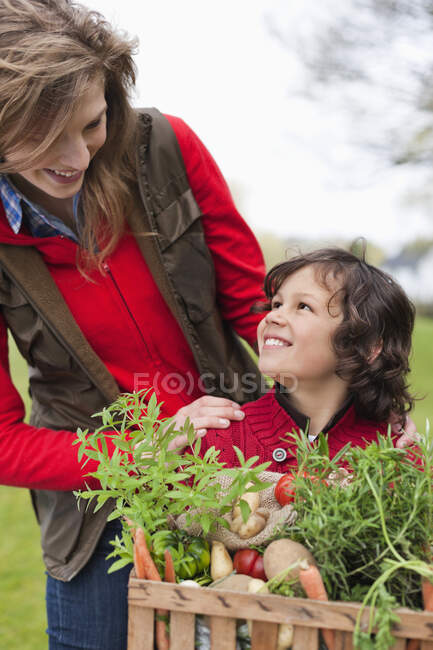 Mère et fils avec une caisse de légumes maison — Photo de stock