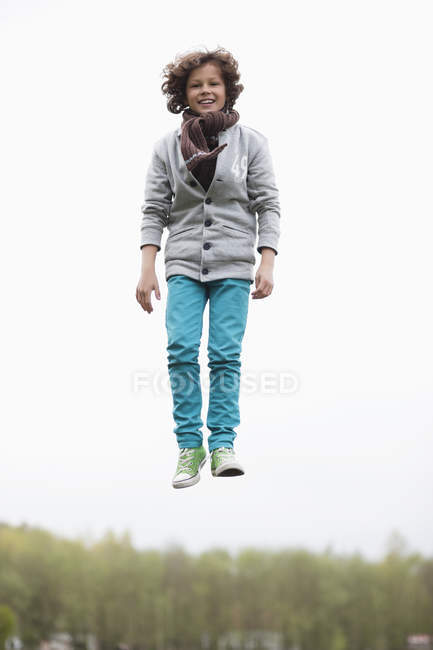 Портрет веселого хлопчика, що стрибає на осінньому полі — стокове фото