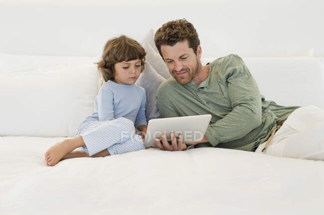 Homem mostrando um tablet digital para seu filho — Fotografia de Stock