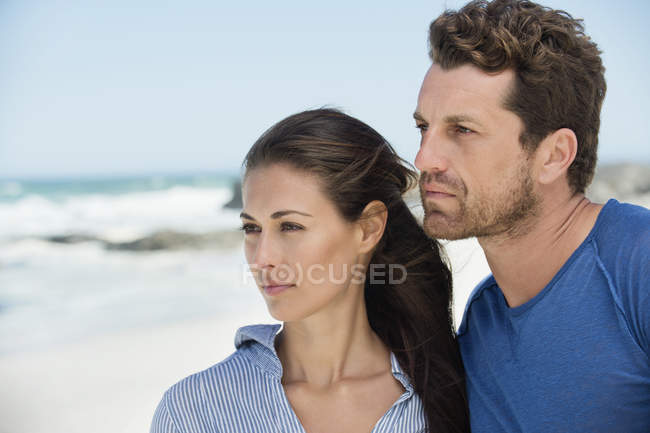 Nachdenkliches Paar schaut am Strand weg — Stockfoto