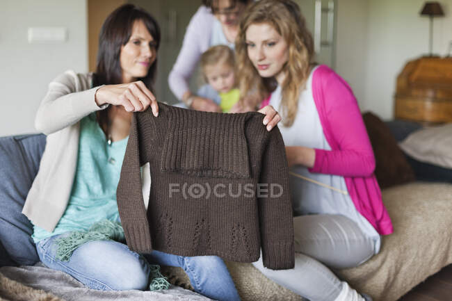 Жінка і її дочка дивляться светр — стокове фото