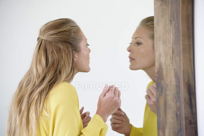 Елегантної жінки, вивчаючи макіяж в дзеркало — стокове фото
