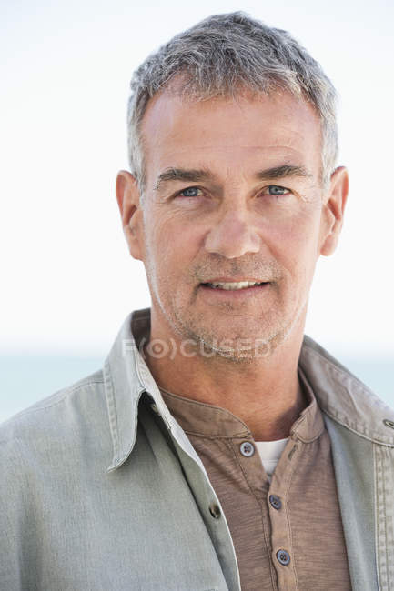 Portrait of thoughtful confident mature man looking at camera outdoors — Stock Photo
