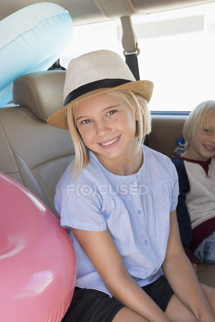Happy children in car with beach gears for vacation — Stock Photo