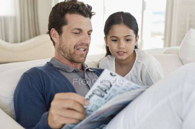 Homem e sua filha lendo uma revista — Fotografia de Stock