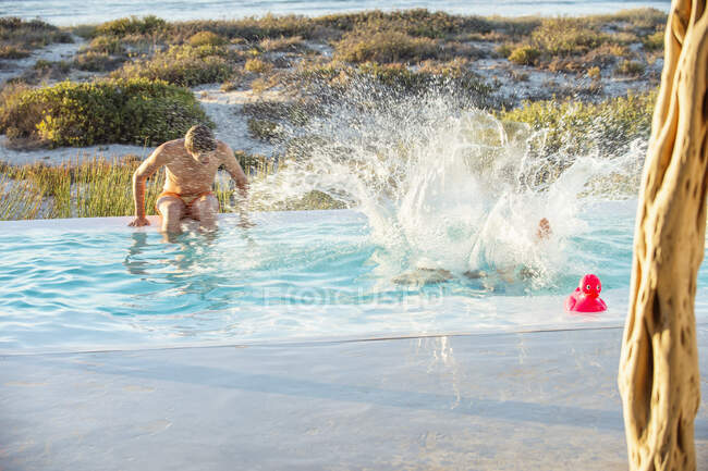 Двое друзей-мужчин наслаждаются в бассейне на пляже — стоковое фото