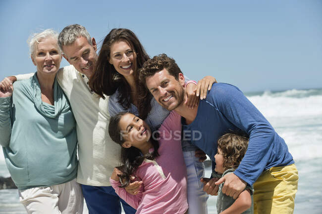 Familia sonriendo en la playa - foto de stock