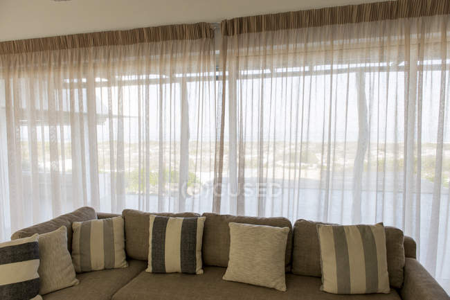 Серый диван с подушками в гостиной — стоковое фото