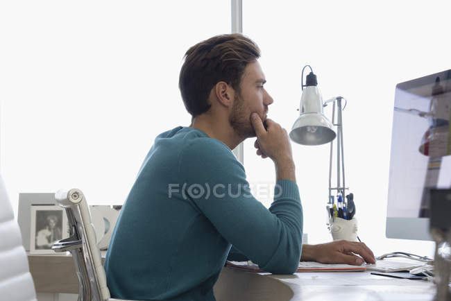 Young businessman working on computer in office — Stock Photo