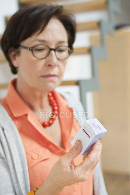 Senior femme en lunettes lecture prescription — Photo de stock