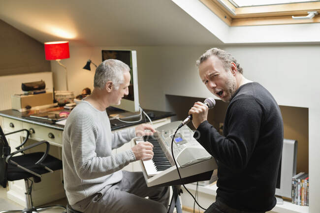Двоє друзів чоловічої статі грають на піаніно і співають — стокове фото