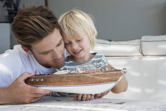 Счастливые отец и сын с моделью лодки — стоковое фото