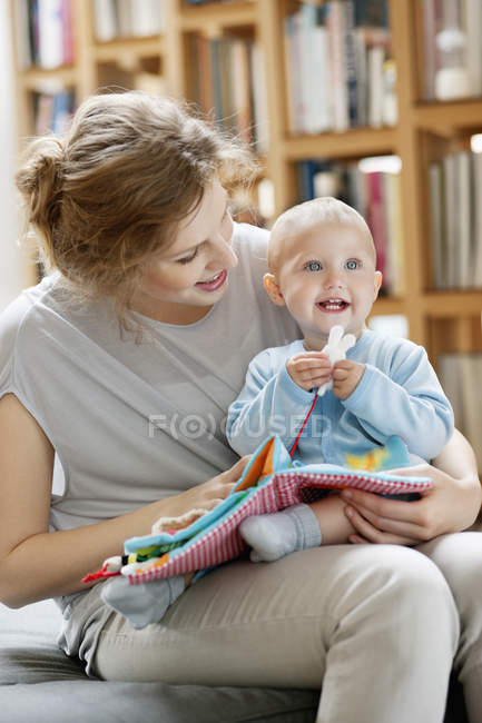 Donna che legge il libro di foto dalla figlia del bambino — Foto stock