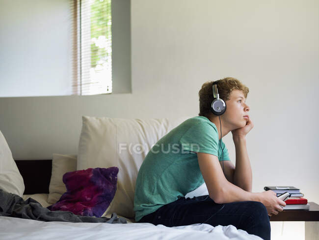 Мальчик-подросток слушает музыку на мобильном телефоне — стоковое фото