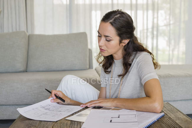 Konzentrierte Frau erledigt Papierkram zu Hause — Stockfoto