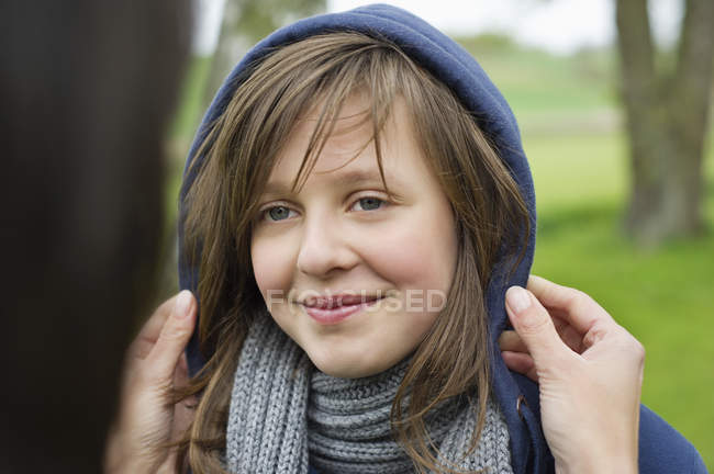 Hände der Mutter verwöhnen lächelnde Tochter im Freien — Stockfoto
