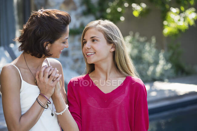 Primer plano de una mujer y su hija sonriendo juntas - foto de stock
