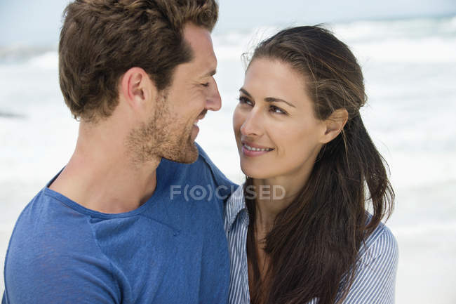 Крупный план счастливой романтической пары, смотрящей друг на друга на пляже — стоковое фото