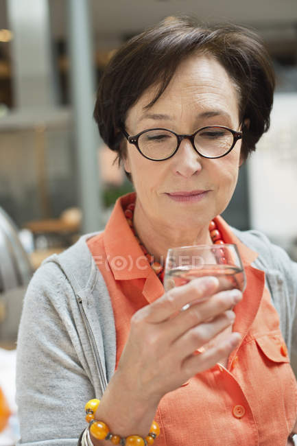 Primer plano de la mujer mayor sosteniendo un vaso de agua - foto de stock