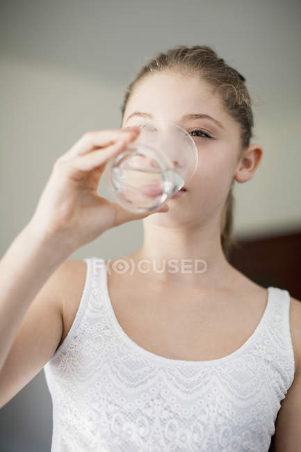 Portrait of teenage girl drinking glass of water — Stock Photo