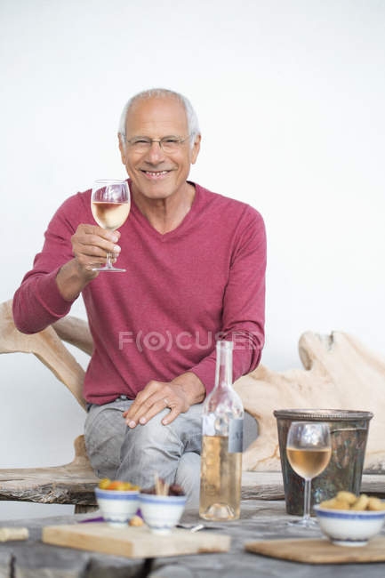 Щасливий старший чоловік насолоджується келихом вина — стокове фото