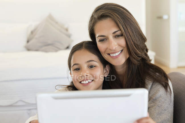 Жінка і її дочка дивляться на цифровий планшет — стокове фото