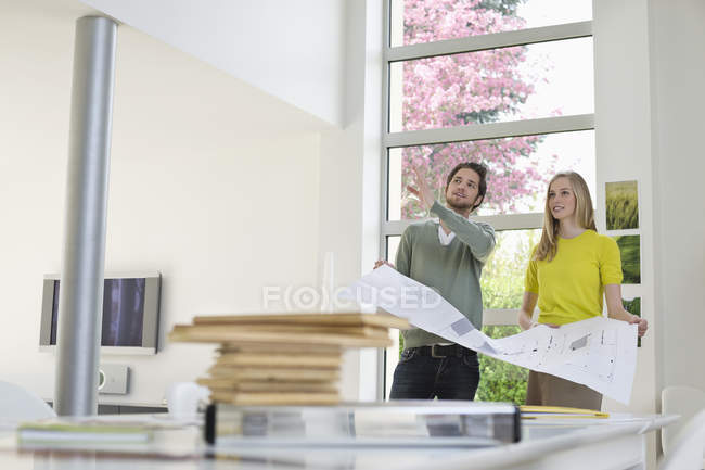 Interior designer discussing plan with young woman — Stock Photo