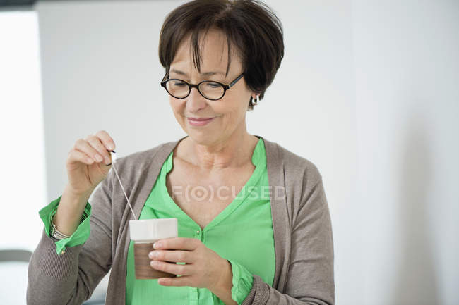 Улыбающаяся пожилая женщина с чашкой чая — стоковое фото