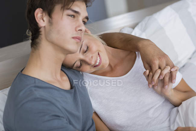 Glückliches junges Paar entspannt sich morgens im Bett — Stockfoto