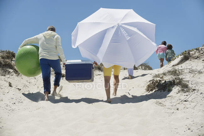 Familia caminando por la playa - foto de stock