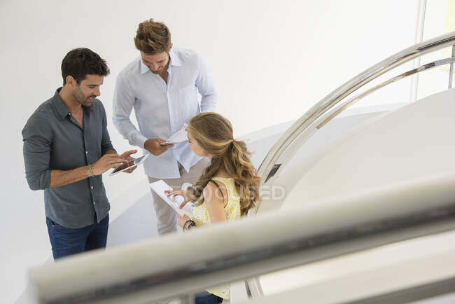 Three happy friends looking at digital tablet — Stock Photo